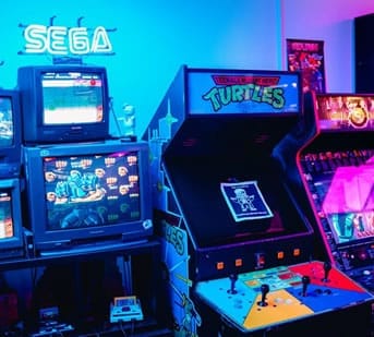 Vintage arcade gaming setup featuring SEGA and Teenage Mutant Ninja Turtles machines.